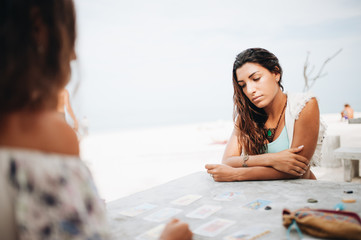 Woman is reading Tarot cards at the beach