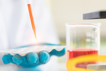 Scientist dropping liquid to sample tray..