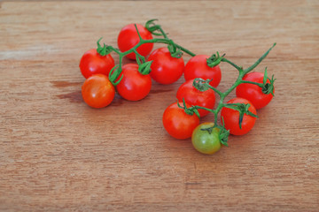 Small Tomato on wood background.Food concept.