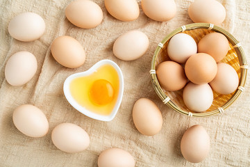 Raw bamboo basket with raw eggs on burlap background