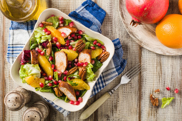 Spring salad with chicken, pomegranate, orange, pecan nuts and honey.