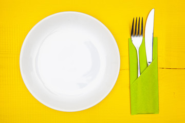 White plate and red Christmas decoration on the white wooden table.Top view. Flat Lay Image.