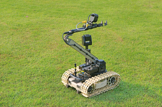 Bomb detection and disposal robot on green grass field.