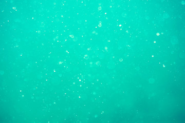 Underwater turquoise texture in ocean. Bubbles in tropical sea.