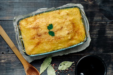 Potato casserole with meat on a wooden table Potato casserole with meat in a transparent plate
