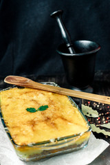 Potato casserole with meat on a wooden table Potato casserole with meat in a transparent plate