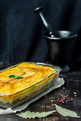 Potato casserole with meat on a wooden table Potato casserole with meat in a transparent plate