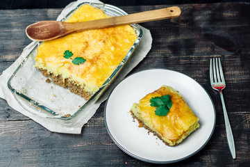Potato casserole with meat on a wooden table Potato casserole with meat in a transparent plate