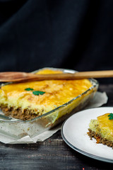 Potato casserole with meat on a wooden table Potato casserole with meat in a transparent plate