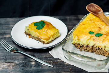 Potato casserole with meat on a wooden table Potato casserole with meat in a transparent plate