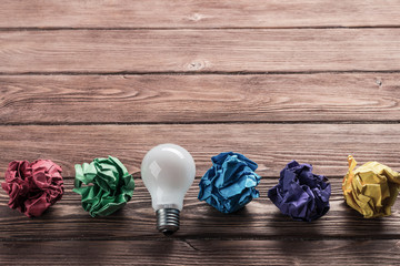 Ideological concept with wastepaper light bulb on wooden table
