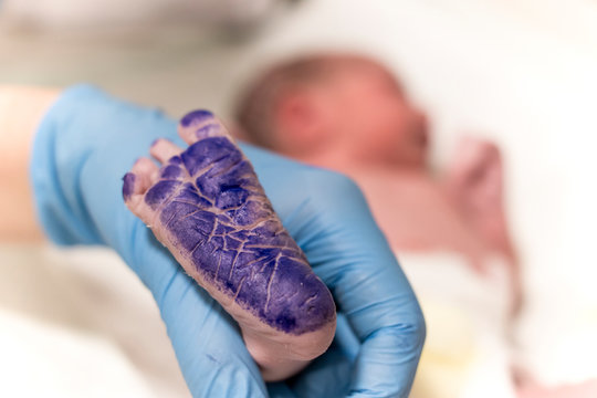 newborn baby footprint in hospital and blue ink over