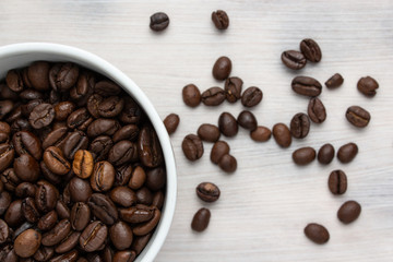 Coffee beans in a white cup on a white background.