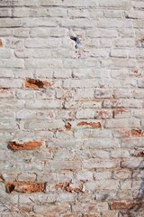 Close up background of brick wall, different shape adobe, vertical rough abstract shabby old worn surface texture photo
