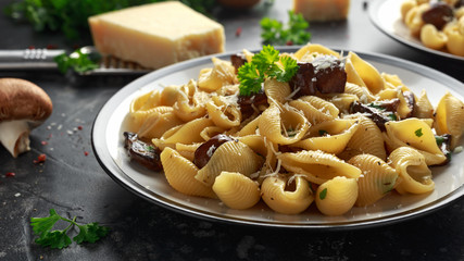 Conchiglie pasta with mushrooms, creamy sauce, parmesan cheese and herbs