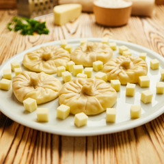 Georgian dumplings Khinkali with cheese, greens and tomato spicy sauce Satsebeli on white plate