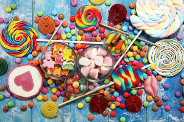 Fototapeta na wymiar candies with jelly and sugar. colorful array of different childs sweets and treats on blue