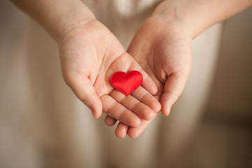 child hands holding red heart, health care, love and family concept, world heart day