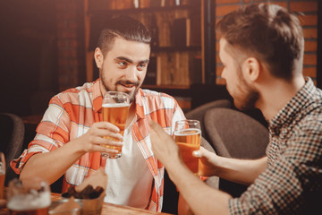 Party in pub, clinking glasses of beer, funny friends laugh