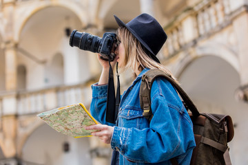 Young woman, professional photographer with camera in old castle