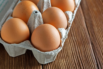 eggs in a paper tray on wooden background