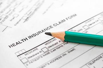 Pencil on health insurance claim form. Close up.