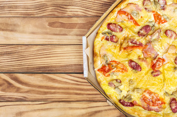 Pizza in pizza box on the table. Close up. Top view. Space for text.