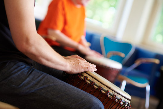Zwei Menschen trommeln auf einer Djembe