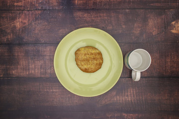 Bread with jam on green plate and cup of milk for breakfast