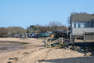 Maningtree Suffolk Uk  - 1 April  2019:  Row  wooden beachside homes on beach