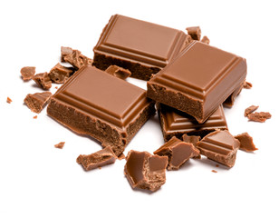 Milk organic chocolate pieces isolated on white background