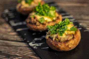 Stuffed mushrooms on a rough wooden surface