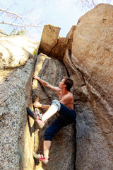 rock climber climbs a boulder over a rock without insurance