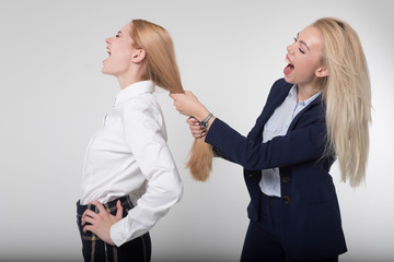 The girl pulls the hair of his colleague. Fighting in the workplace