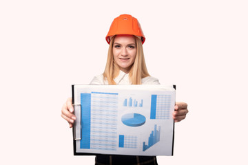 Girl engineer in a protective helmet shows graphics