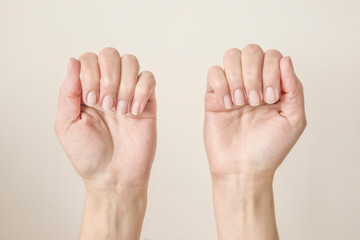 female hands with folded fingers showing nails