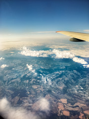 Fototapeta premium View from airplane window at wetlands and residential area, flying above Europe. Aerial perspective. 