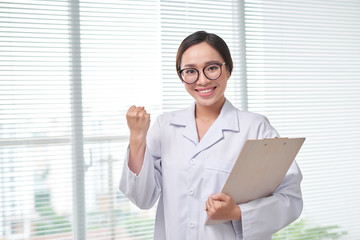 Beautiful smiling doctor woman in medical gown