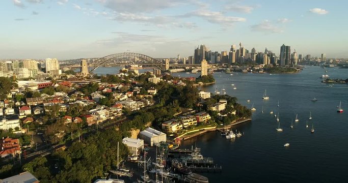 Berry bay on Sydney Harbour against Sydney city CBD high-rise towers and landmarks in aerial panning.