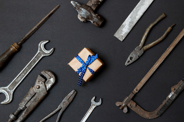 Craft gift with vintage old tools on black paper background. Fathers day concept. Flat lay