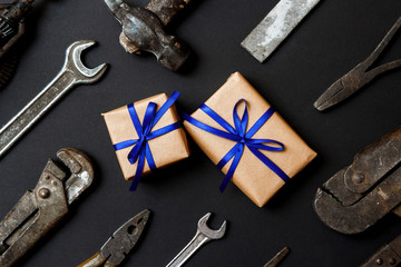 Two craft gifts with vintage old tools on black paper background. Fathers day concept. Flat lay