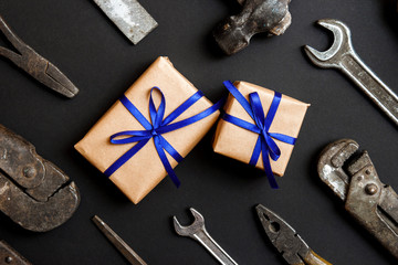 Two craft gifts with vintage old tools on black paper background. Fathers day concept. Flat lay