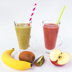 Two different colors cocktails in glass cups with straw. Banana, kiwi and apple fruits. Healthy smoothies, white background.
