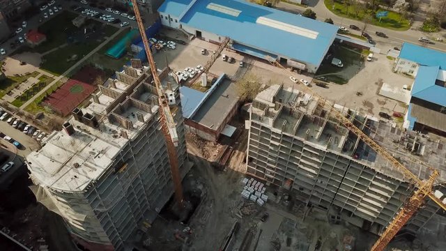Crane near unfinished building, top view.
