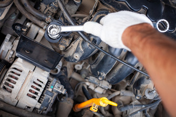 mechanic men with wrench repairing car engine at
