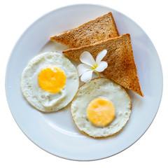 Fried eggs with toast on a white plate decorated with a tropical flower. Delicious healthy breakfast at a tropical resort. isolated