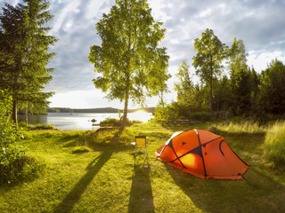 camping am See, oranges Zelt an einem See - obrazy, fototapety, plakaty