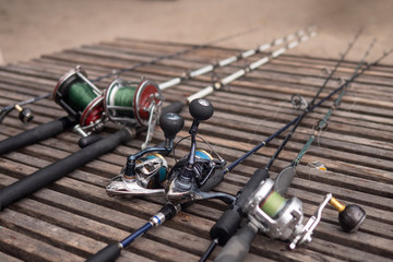 Fishing rods, spinning rods with fishing line on a wooden background in the morning light. Fishing.
