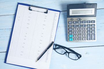 document with glasses and calculator on desk