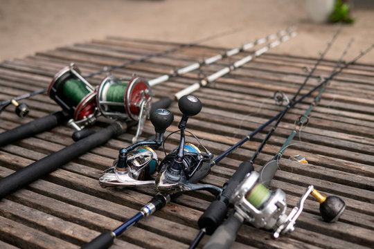 Fishing rods, spinning rods with fishing line on a wooden background in the morning light. Fishing.